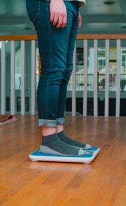 A person in Athens, GA stands on Health Wealth Safe’s weighing device, one foot resting on it.